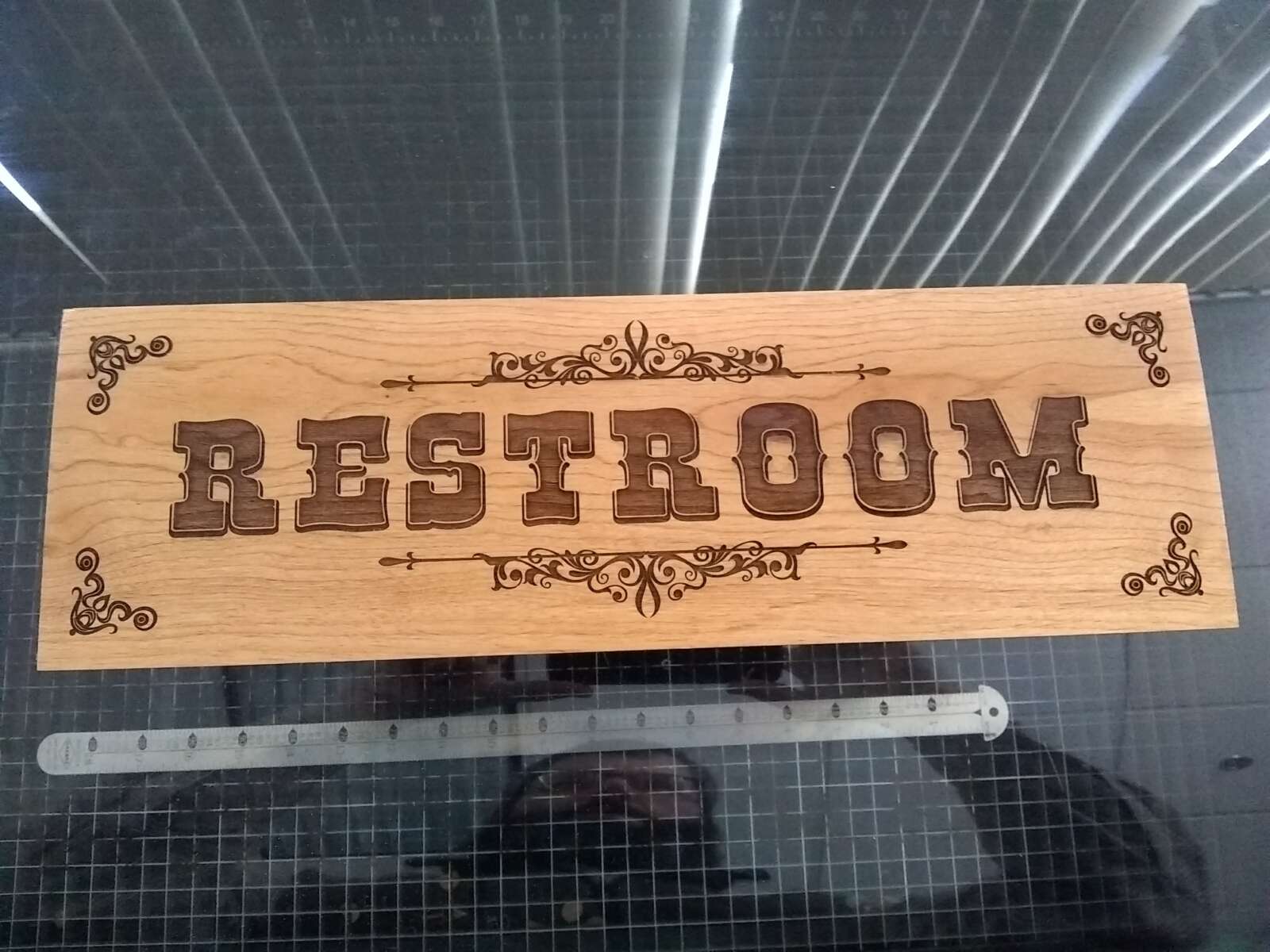 Restroon sign A wooden restroom sign that has been laser engraved